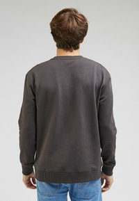 Grå sweatshirt i bomullsblandning, med ribbad rund halsringning och mudd, en slät textur och avslappnad passform.