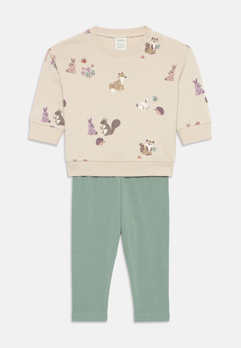 Felpa beige con motivi animali; colletto rotondo, tessuto morbido. Leggings verdi, vita elastica, design aderente, texture liscia.