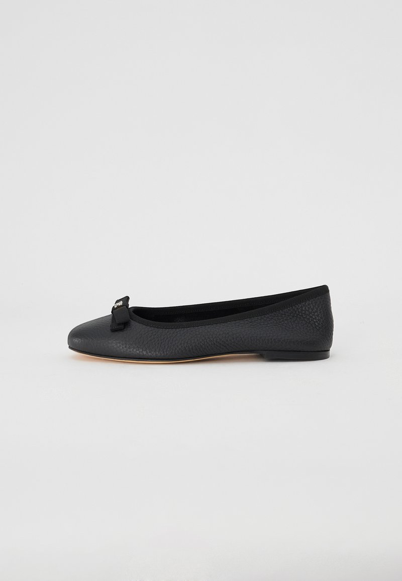 Schwarzes Leder-Ballettschuh mit strukturiertem Finish, elastischem Rand und einer kleinen Schleifenakzent an der Zehenpartie. Flache, niedrige Sohle.