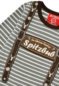 Striped shirt in muted green and white, featuring brown embroidered suspenders and a patch with the text "SpitzBub." Includes decorative buttons.