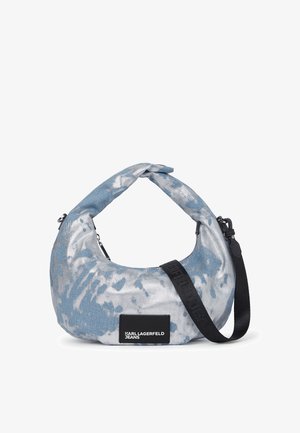Hobo bag in blue tie-dye fabric with a twisted handle and a black strap. Features a logo patch and a smooth texture with a structured shape.