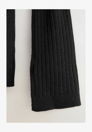 Czarna, prążkowana tkanina swetra o miękkiej fakturze. Projekt ma poziome żłobienia. Rękawy są dziane i lekko postrzępione na brzegach.