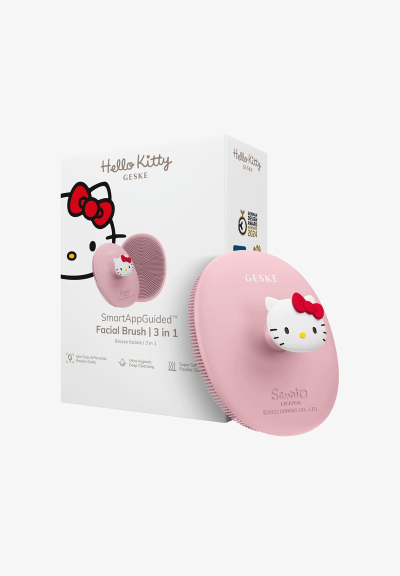 Pink Hello Kitty-themed facial brush with silicone bristles, red bow detail, and packaging highlighting 3-in-1 SmartAppGuided deep cleansing.