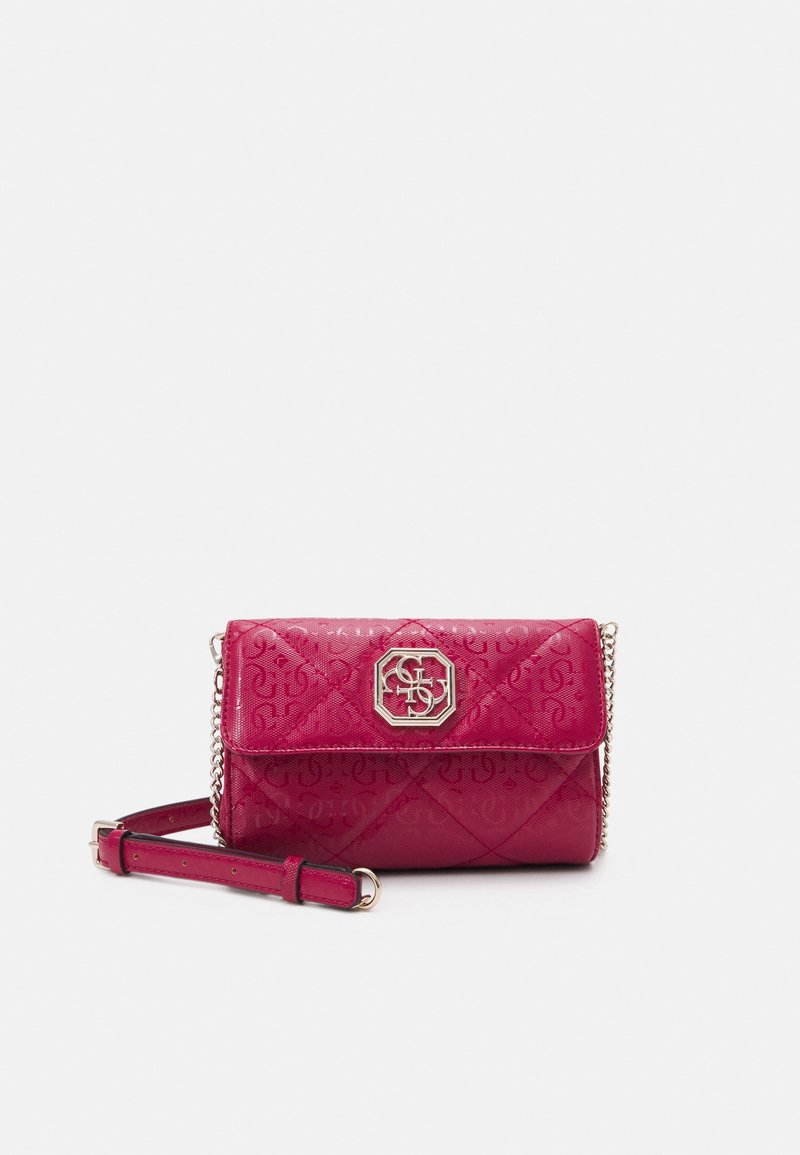 Pudderrosa quiltet håndtaske i imiteret læder med kæderem, der har en dekorativ metal logo-lås og et præget monogrammønster på overfladen.