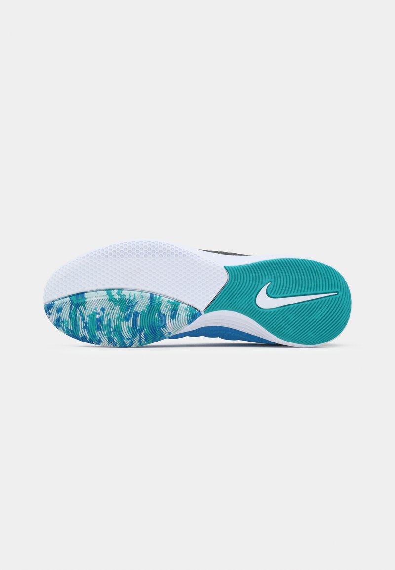 Nike-sko-sula med en strukturerad vit yta och turkosa accenter; har ett mönstrat grepp i turkos och blått.