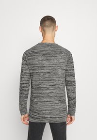 Harmaa marmorikoosteinen pitkähiha Shirt, jossa on pyöreä kaula-aukko, ribbaatut hihansuut ja teksturoitu kangaskuvio. Yksinkertainen takasuunnittelu.