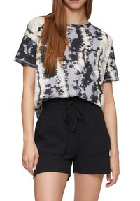T-shirt tie-dye à coupe décontractée en gris, noir et crème, associé à un short noir à cordon de serrage avec poches latérales et texture douce.