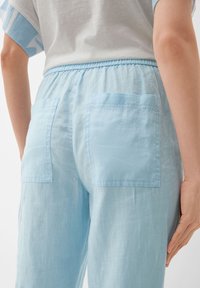 Lichtblauwe linnen broek met een elastische tailleband en twee achterzakken, met een zachte, gestructureerde stof en een relaxte pasvorm.