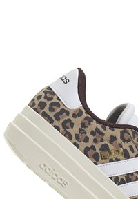 Leopardmönstrade sneakers med vita läderdetaljer, tjock krämfärgad sula och guld-logotyp. Har en strukturerad yta och vadderad krage.