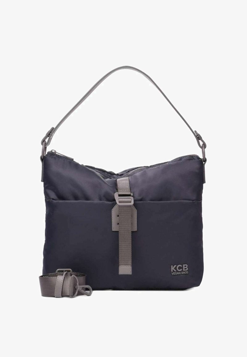 Bolso vegano azul marino con textura acolchada, correa gris ajustable y cierre frontal con correa. Diseño minimalista con un logo.