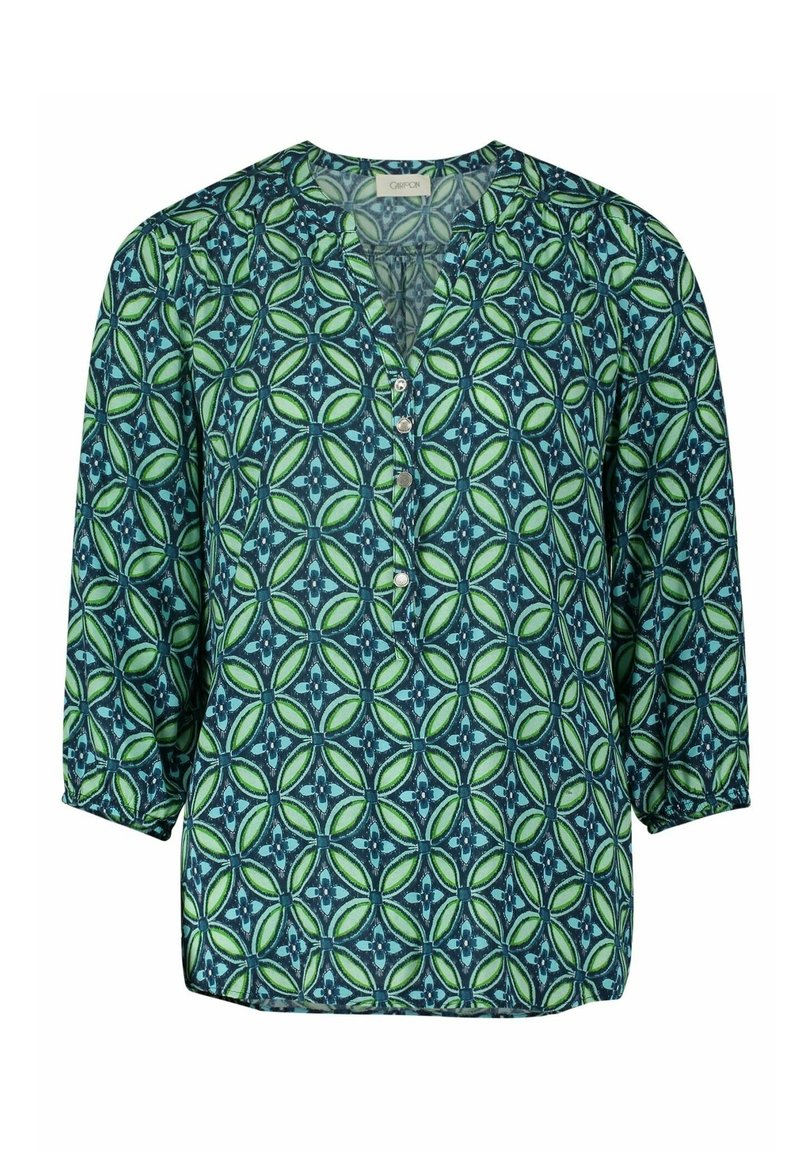Blouse à motifs verts et bleus avec un col en V, des manches trois-quarts et des boutons sur le devant. Tissu lisse avec un imprimé géométrique.