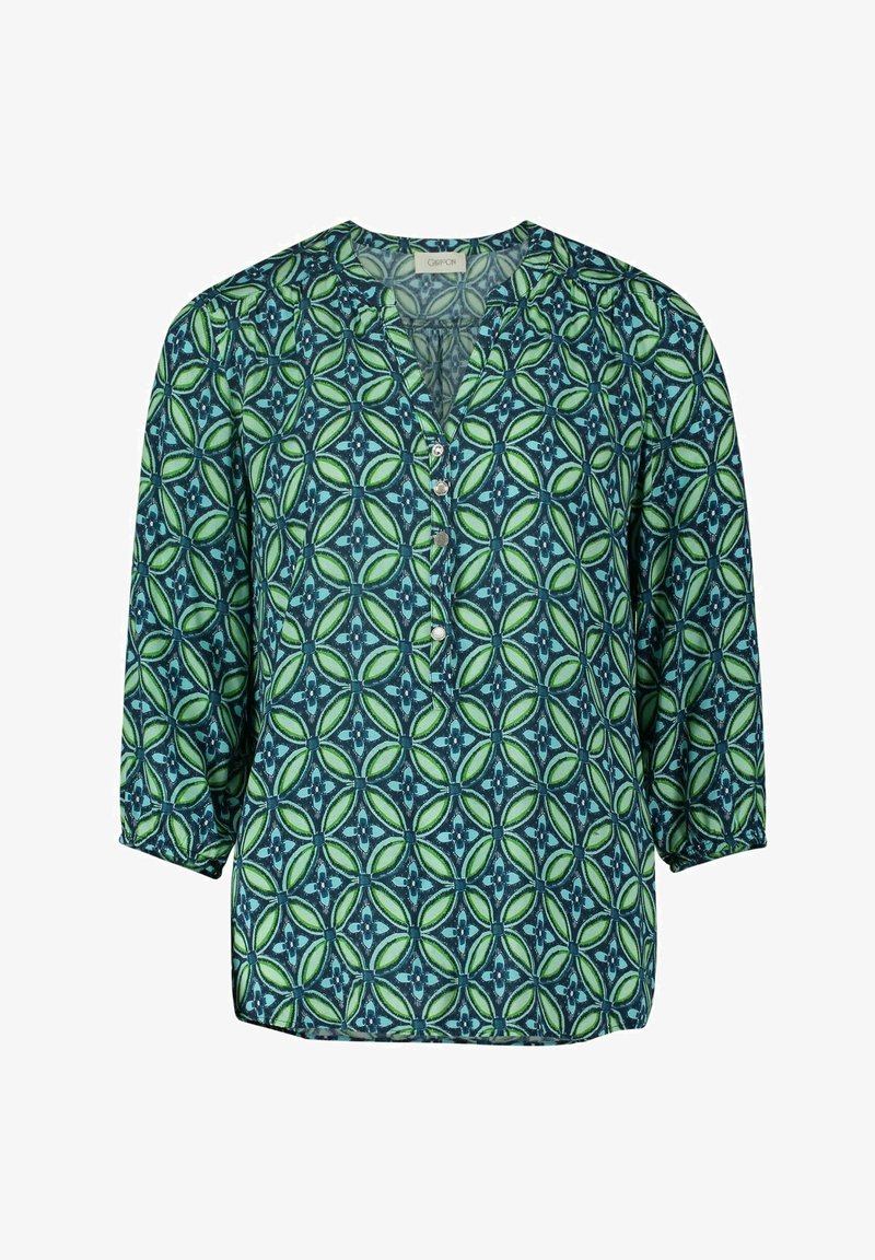 Blouse à motifs verts et bleus avec un col en V, des manches trois-quarts et des boutons sur le devant. Tissu lisse avec un imprimé géométrique.