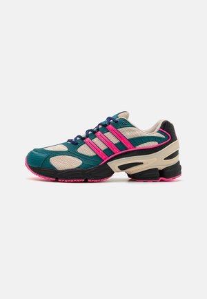 Low-top running shoe with beige mesh, teal overlays, pink stripes, black and beige sole with pink accents, and navy blue laces.