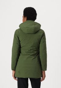 Parka aislante verde con capucha, que presenta una forma ajustada, textura suave y longitud hasta la mitad del muslo. La vista trasera muestra detalles de costura.