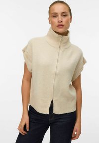 Maglione senza maniche beige lavorato a maglia con colletto alto e zip frontale, presenta dettagli a coste all'orlo e al colletto, texture morbida.