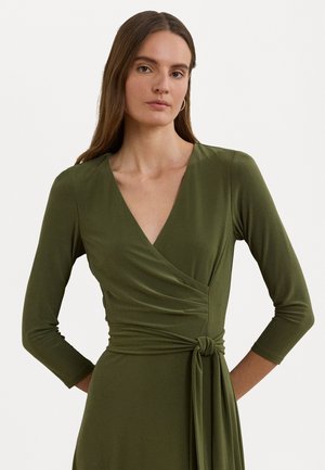 Abito avvolgente verde oliva con maniche lunghe, scollatura a v e dettaglio con nodo laterale; realizzato in materiale morbido e liscio con una sottile texture.
