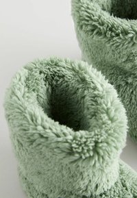 Grüne Plüschbooties mit weichem, flauschigem Material und geschlossenen Oberseiten. Das Material ist dick und bietet Wärme und Komfort für die Füße.