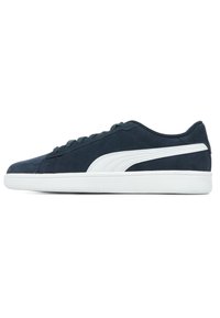 Sneaker in suede blu navy con suola in gomma bianca, caratterizzata da una striscia laterale bianca e sei occhielli metallici per i lacci. Design basso.