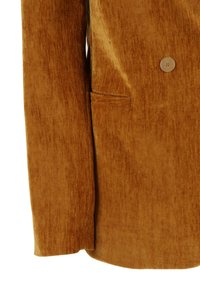 Manica di giacca in velluto marrone a coste e tasca laterale con un bottone visibile sul tessuto strutturato.