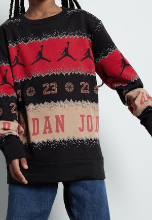 Felpa nera con motivi geometrici rossi e beige, loghi Jordan e numero 23. Vestibilità ampia con maniche lunghe e polsini a costine.