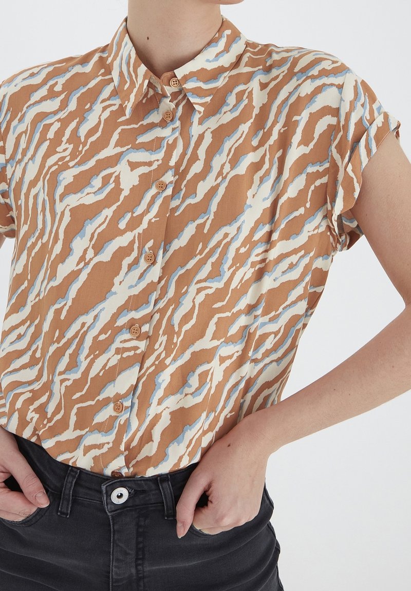 Kurzärmliges, knöpfbares Hemd in braun, creme und hellblauem abstraktem Muster; leichtes Material mit Kragen und aufgerollten Ärmeln.