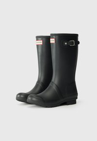Schwarze Gummiregenstiefel mit runder Zehenform, strukturiertem Oberflächenmaterial, verstellbarem Schnallen-Design und weißem Hunter-Logo auf der Vorderseite.