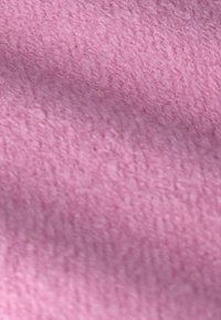 Tissu rose doux avec une surface texturée, présentant une sensation dense et duveteuse. Aucun motif distinct ou accent n'est visible.