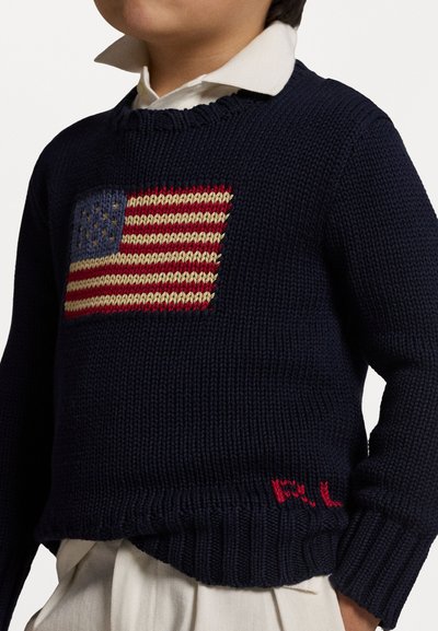 Námornícky modrý pletený sveter s dizajnom americkej vlajky v červenej, bielej a modrej farbe, s rebrovanými manžetami a malým červeným vyšívaným logom.