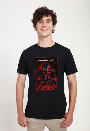 Black cotton t-shirt featuring a red and black graphic of a robotic skull with flames, titled "The Terminator," centered on the front.