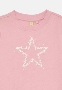Sudadera de algodón rosa con cuello redondo. Presenta una estrella decorativa blanca hecha de estrellas más pequeñas impresa en la parte frontal.