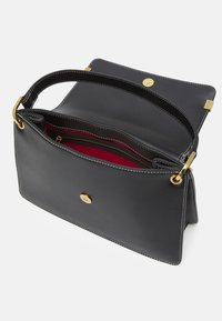 Černá kožená kabelka se zlatými detaily, magnetickým zapínáním a červeným interiérem. Obsahuje více přihrádek a kontrastní bílé stehy.