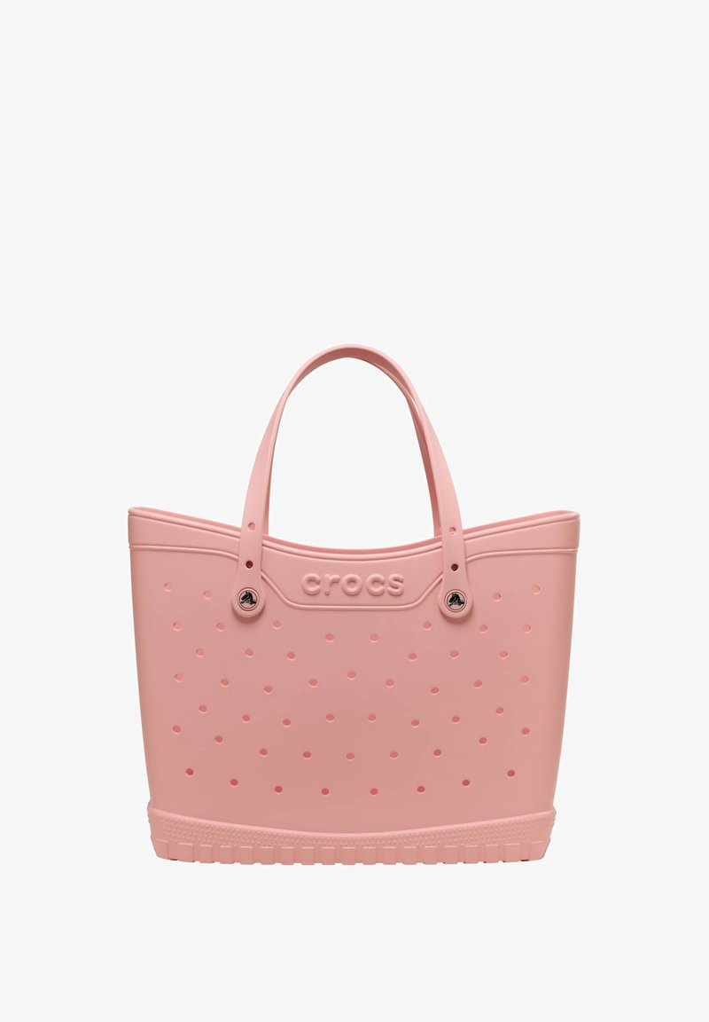 Rosa Crocs Tragetasche mit perforierten Löchern, zwei Griffen und strukturiertem Boden.