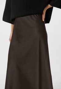 Brown satin maxi skirt with a smooth texture and slight sheen, featuring a high waist and a straight silhouette, seen from the side.