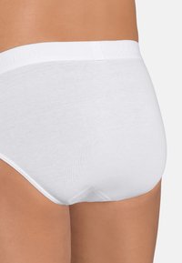 Weisse Baumwollunterhose mit glatter Textur, elastischem Bund mit eingeprägtem Logo und nahtlosem Design auf der Rückseite für zusätzlichen Komfort.