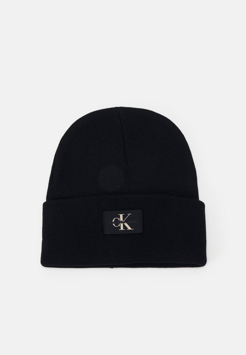 Bonnet en maille noire avec revers, présentant un petit patch rectangulaire affichant le logo "cK" Calvin Klein en lettres claires.