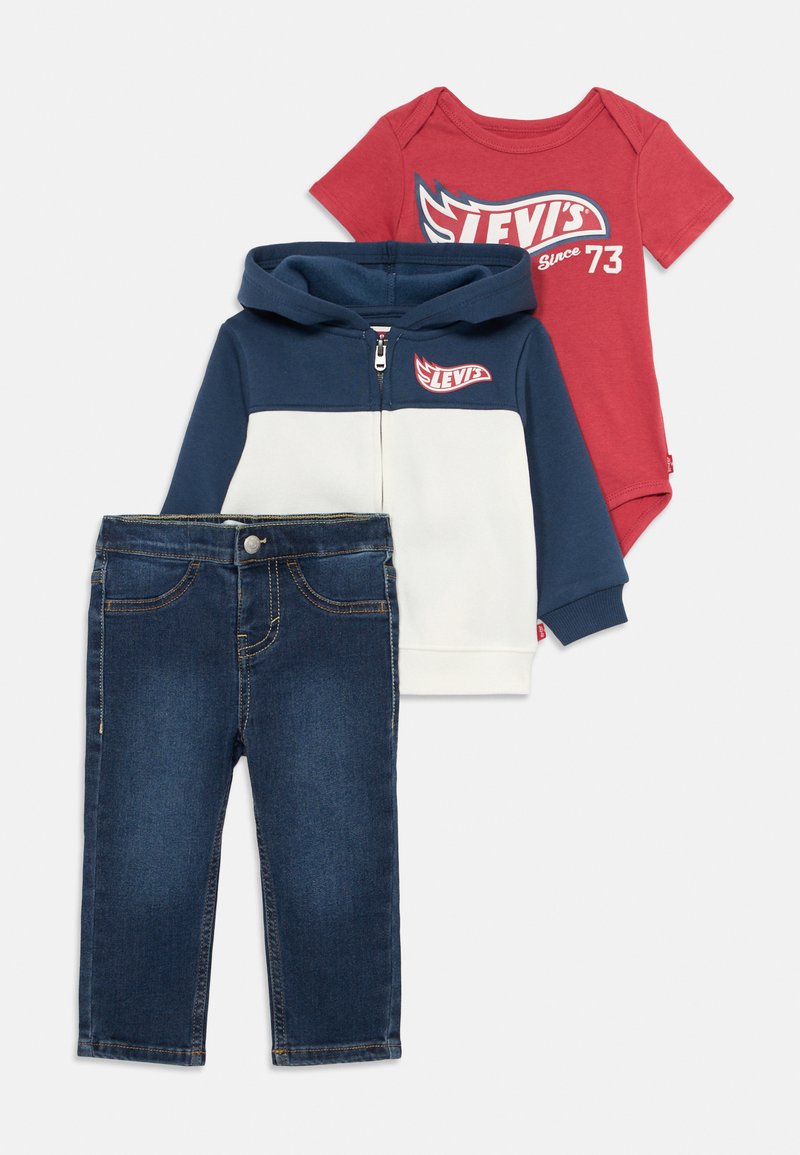 Kolmeosaline laste rõivakomplekt, mis sisaldab punast lühikeste varrukatega bodysuit't, tumesinist ja valget lukuga kapuutsiga jakki ning tumedat teksapüksi.