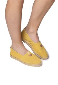 Espadrillas in tela gialla con accenti in pelle marrone, suola piatta, stile slip-on e un design semplice con un'apertura frontale.