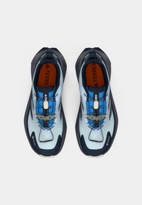 Ανοιχτό γαλάζιο και ναυτικό μπλε παπούτσια πεζοπορίας με υφασμάτινο επάνω μέρος, ευλύγιστες σόλες και ενσωματωμένο σύστημα κορδονιών. Διαθέτουν λογότυπο Gore-Tex και πορτοκαλί εσωτερικό.