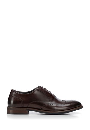 Scarpa elegante da uomo in pelle marrone scuro con dettagli brogue, chiusura con lacci e tacco basso impilato su sfondo bianco.