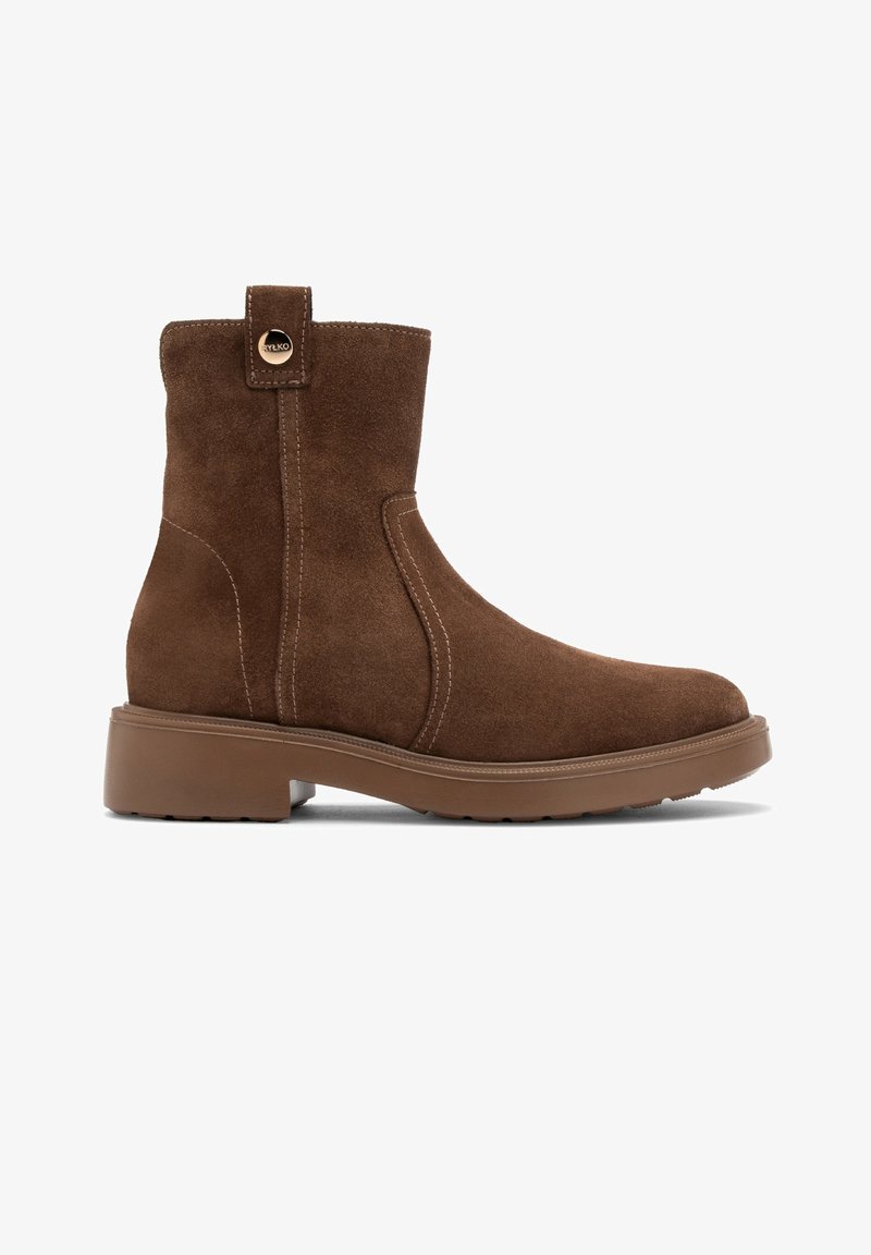 Brązowy zamszowy botek za kostkę z zaokrąglonym noskiem, detalami przeszycia i beżową gumową podeszwą. Posiada pętlę z tyłu ułatwiającą zakładanie.