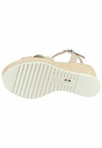 Beige kilehæle sandal med en vævet jute mellemsål og gummisål. Har en spændebånd og en struktureret sål for komfort. Størrelse 35.