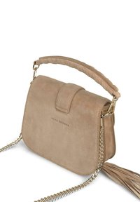 Bolso de hombro de ante beige con un asa trenzada en la parte superior, correa de cadena dorada y un acento decorativo en forma de borla. Cierre magnético en la parte delantera con solapa.