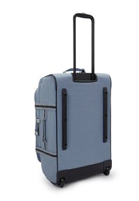 Maleta de tela azul con un asa retráctil negra, ruedas de patín en línea, bolsillos laterales y acentos negros en contraste.