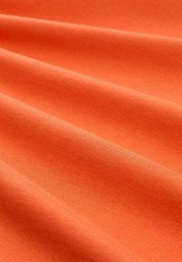 Pomarańczowa bawełniana tkanina o gładkiej fakturze, z delikatnymi zagnieceniami i jednolitym wykończeniem na całej powierzchni.