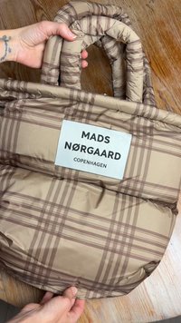Borsa tote trapuntata beige con motivo a quadri marrone. Presenta manici imbottiti e un'etichetta bianca con la scritta "MADS NØRGAARD COPENHAGEN."