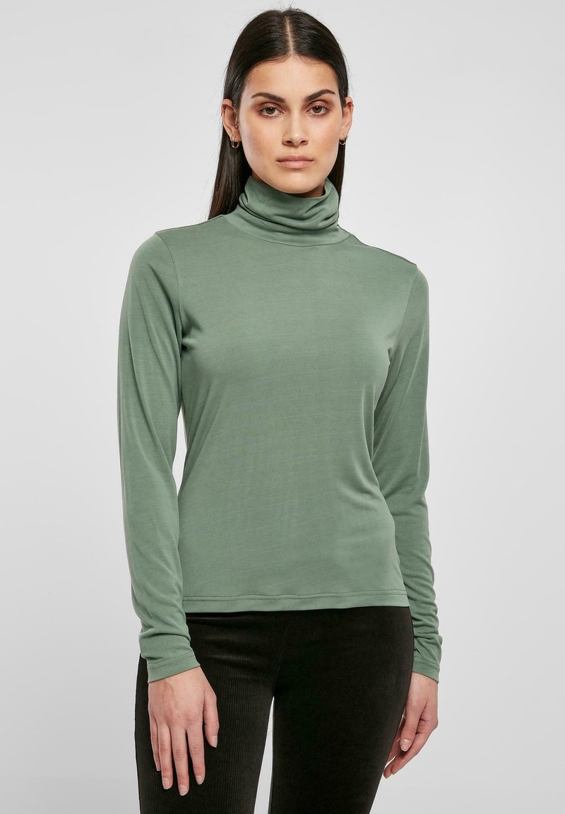 Pulover cu guler înalt, cu mânecă lungă, de culoare verde discretă, realizat dintr-un material moale și elastic. Prezintă o siluetă ajustată și manșete înguste.