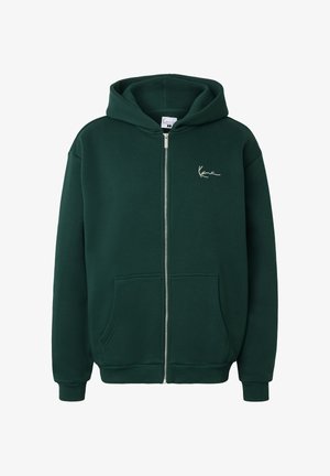 Tummanvihreä vetoketjullinen huppari, jossa on etutaskut, ribbineulotut hihansuut ja pieni valkoinen allekirjoituslogo vasemmassa rinnassa.