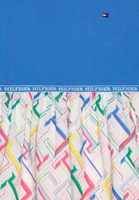 Niebieski bawełniany top z teksturowanym wzorem oraz kolorową spódnicą w geometryczny nadruk. Posiada białą taśmę z logo "HILFIGER".