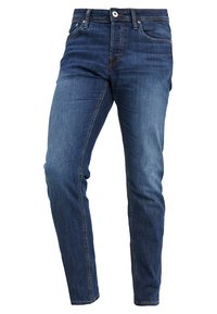 Jeans de mezclilla azul oscuro con un ajuste slim. Las características incluyen una cinturilla estándar, cremallera en la bragueta, cinco bolsillos y detalles de costura en contraste.