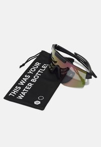 Des lunettes de soleil avec un écran teinté, une monture noire et une pochette en tissu noir portant l'inscription "C'ÉTAIT TA BOUTEILLE D'EAU !" en texte blanc.